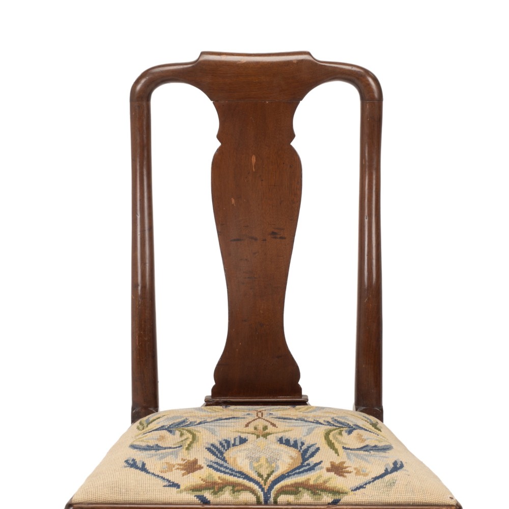 A George II walnut side chair featuring a shaped vasiform splat, cabriole front legs with pad feet, turned stretchers, and a floral needlework drop-in seat. View V