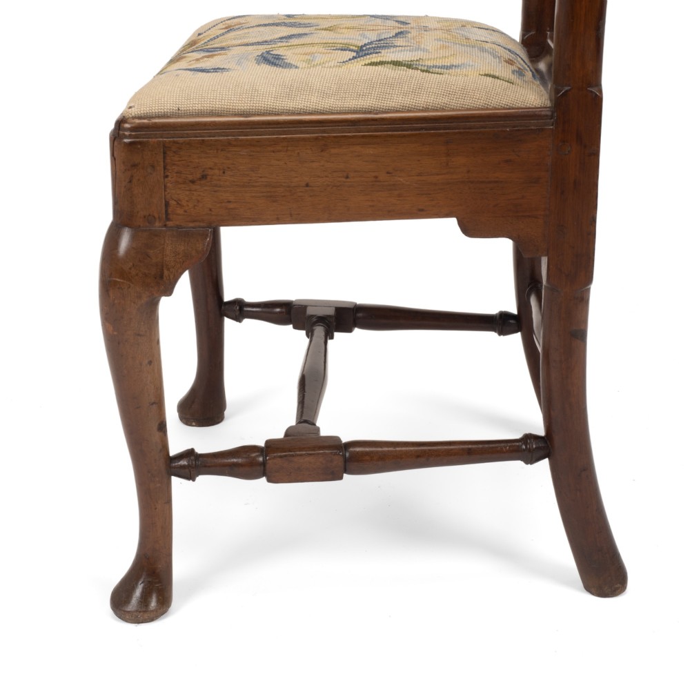 A George II walnut side chair featuring a shaped vasiform splat, cabriole front legs with pad feet, turned stretchers, and a floral needlework drop-in seat. View VII