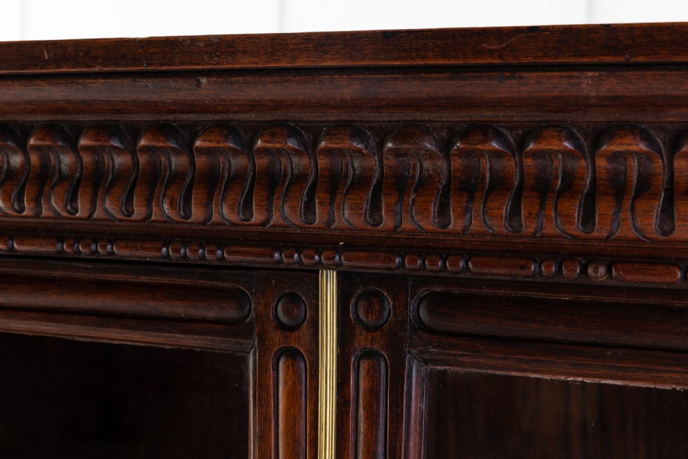 A nineteenth-century Anglo-Indian breakfront bookcase made of dark padouk wood with four glazed doors and carved upper mouldings. View III