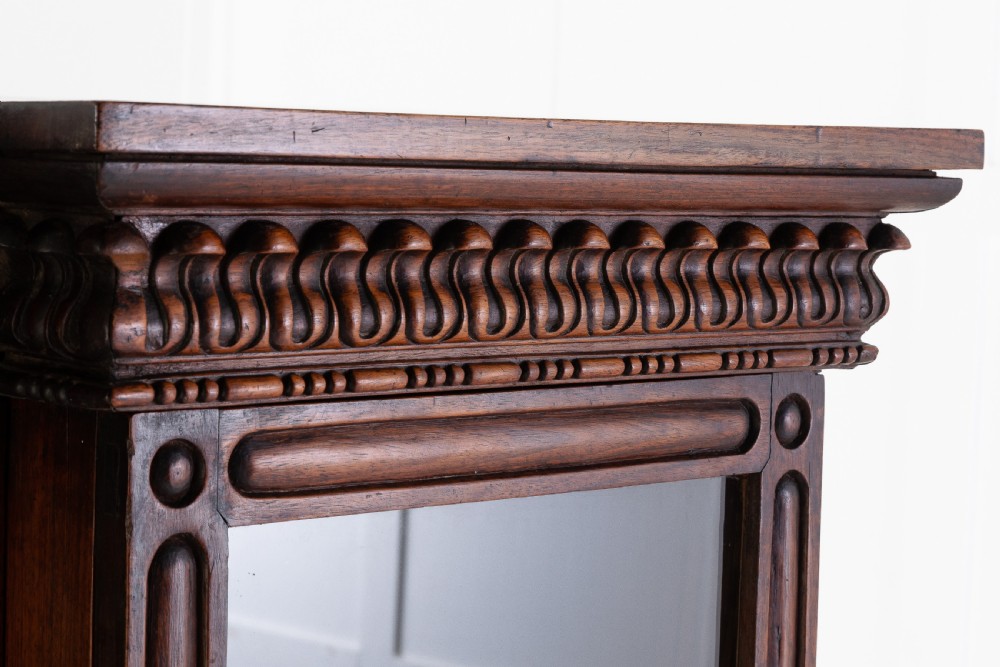 A nineteenth-century Anglo-Indian breakfront bookcase made of dark padouk wood with four glazed doors and carved upper mouldings. View IV