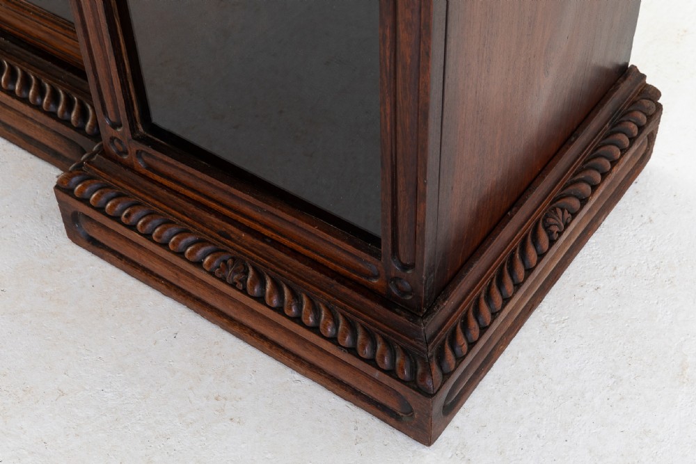 A nineteenth-century Anglo-Indian breakfront bookcase made of dark padouk wood with four glazed doors and carved upper mouldings. View VII