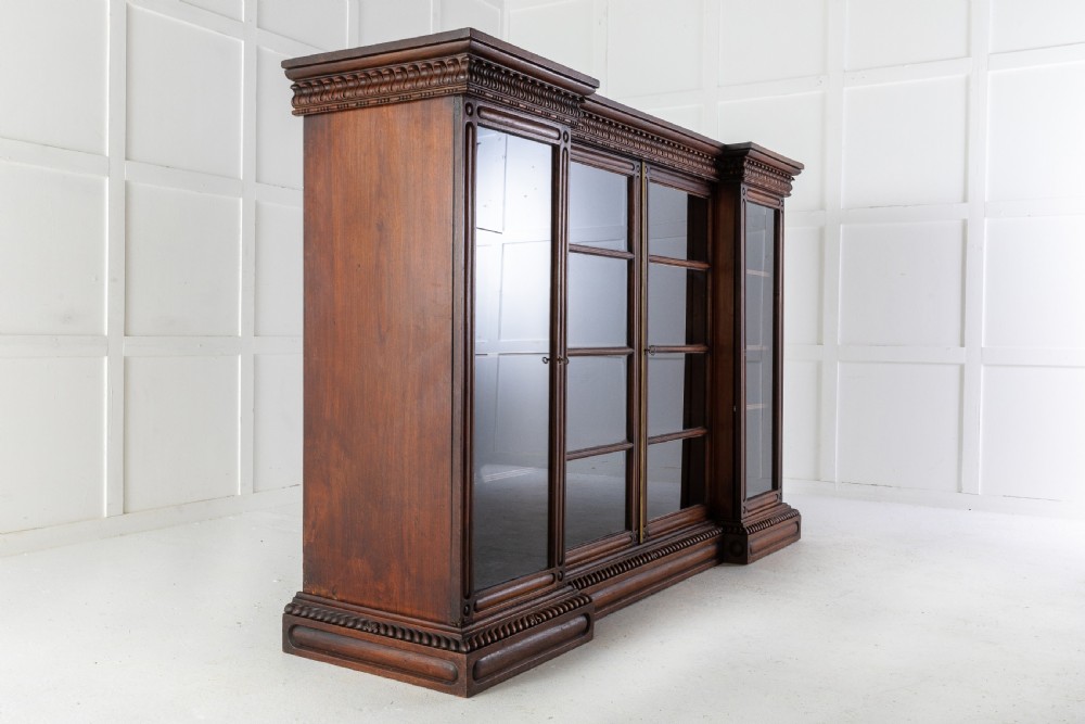 A nineteenth-century Anglo-Indian breakfront bookcase made of dark padouk wood with four glazed doors and carved upper mouldings. View IX