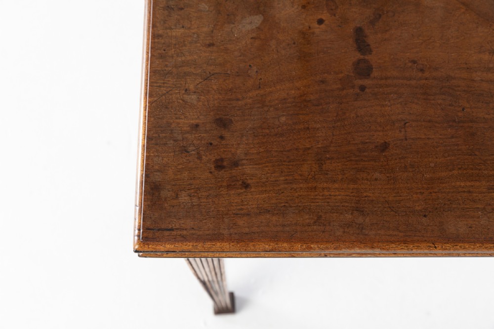 An 18th-century George III mahogany tea table featuring fluted tapering square legs, a reeded frieze with central carved floral swags, and a fold-over top. View VIII