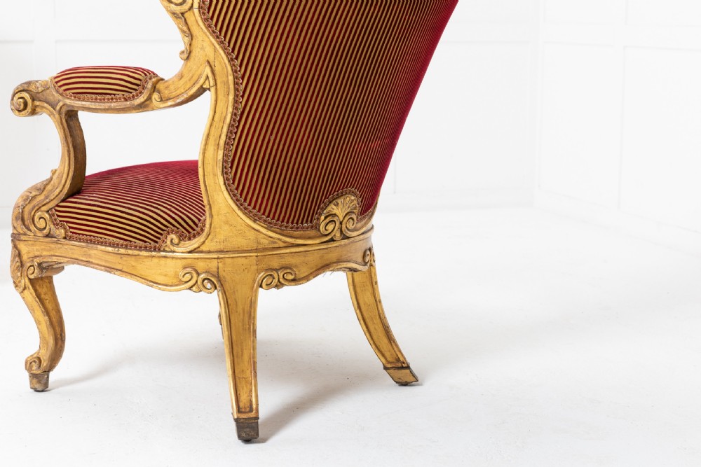 A pair of 18th-century Italian giltwood armchairs with carved scroll motifs and red and gold striped fabric upholstery. View VIII