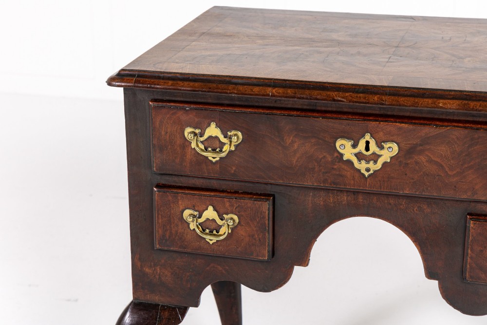 A George II mahogany lowboy featuring three drawers, brass backplate handles, a shaped apron, and four cabriole legs with pad feet. View II