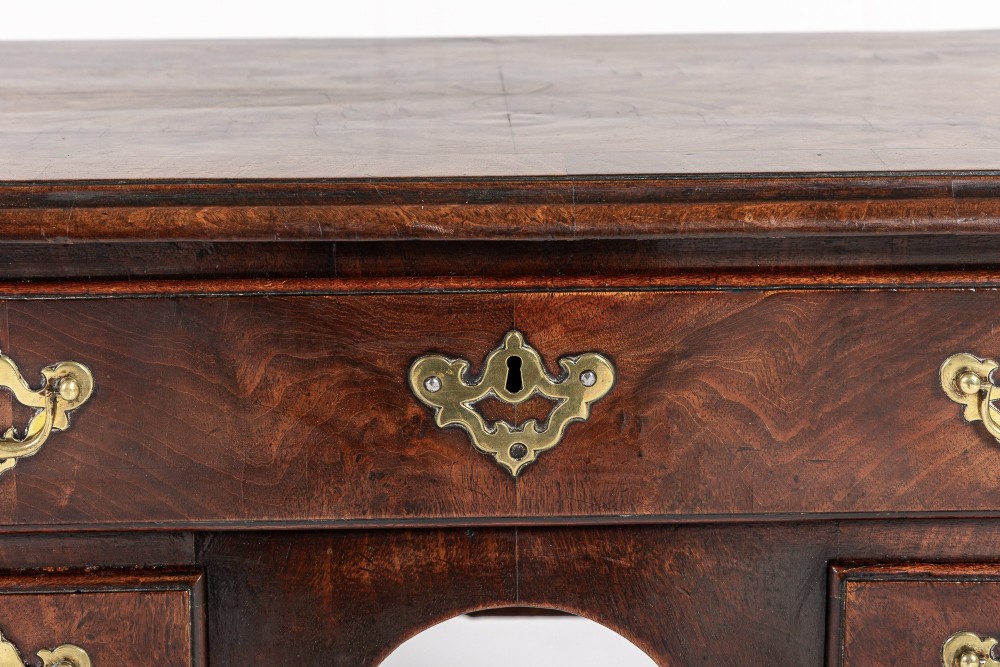 A George II mahogany lowboy featuring three drawers, brass backplate handles, a shaped apron, and four cabriole legs with pad feet. View III