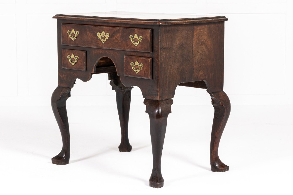 A George II mahogany lowboy featuring three drawers, brass backplate handles, a shaped apron, and four cabriole legs with pad feet. View VI