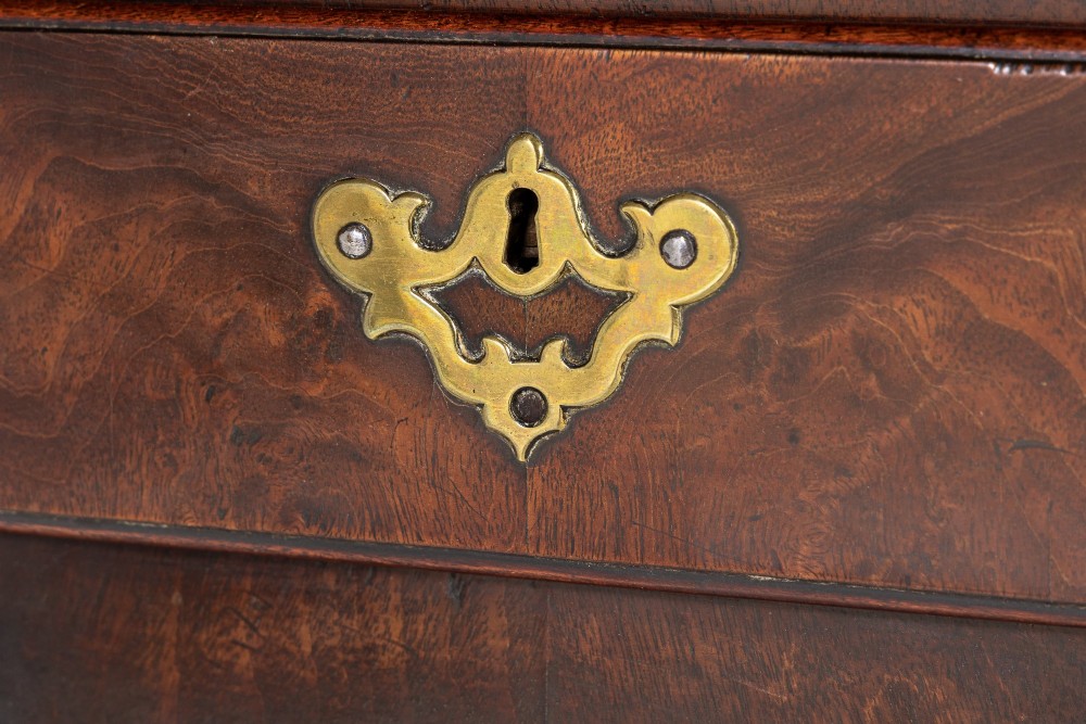 A George II mahogany lowboy featuring three drawers, brass backplate handles, a shaped apron, and four cabriole legs with pad feet. View IX