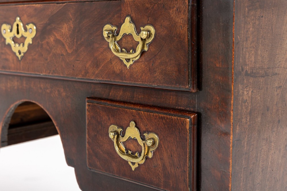 A George II mahogany lowboy featuring three drawers, brass backplate handles, a shaped apron, and four cabriole legs with pad feet. View X