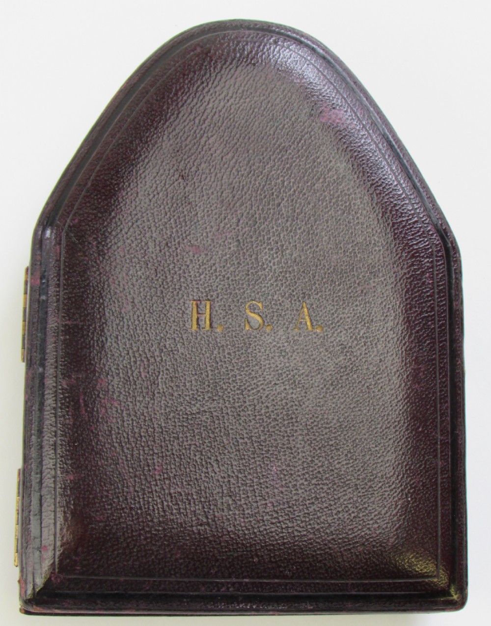 An ornate oval gilt brass strut clock with an engraved dial and moonphase indicator, displayed alongside its fitted velvet-lined carrying case and winding key. View IV