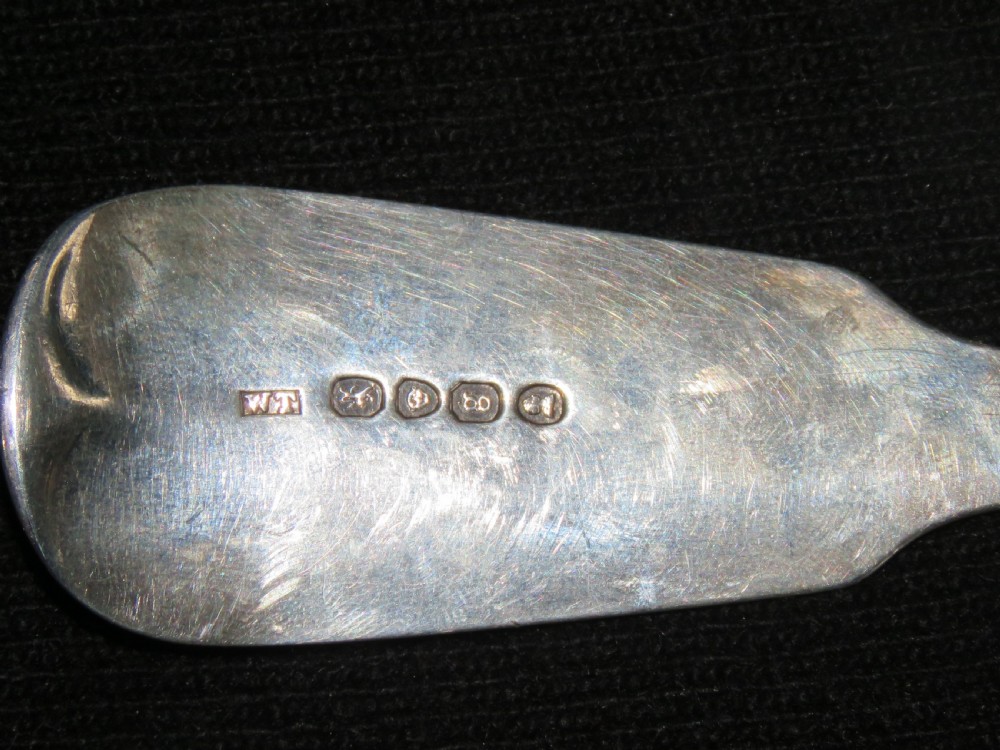 A George III sterling silver basting spoon featuring a plain handle stamped with British hallmarks and a deep oval bowl. View III
