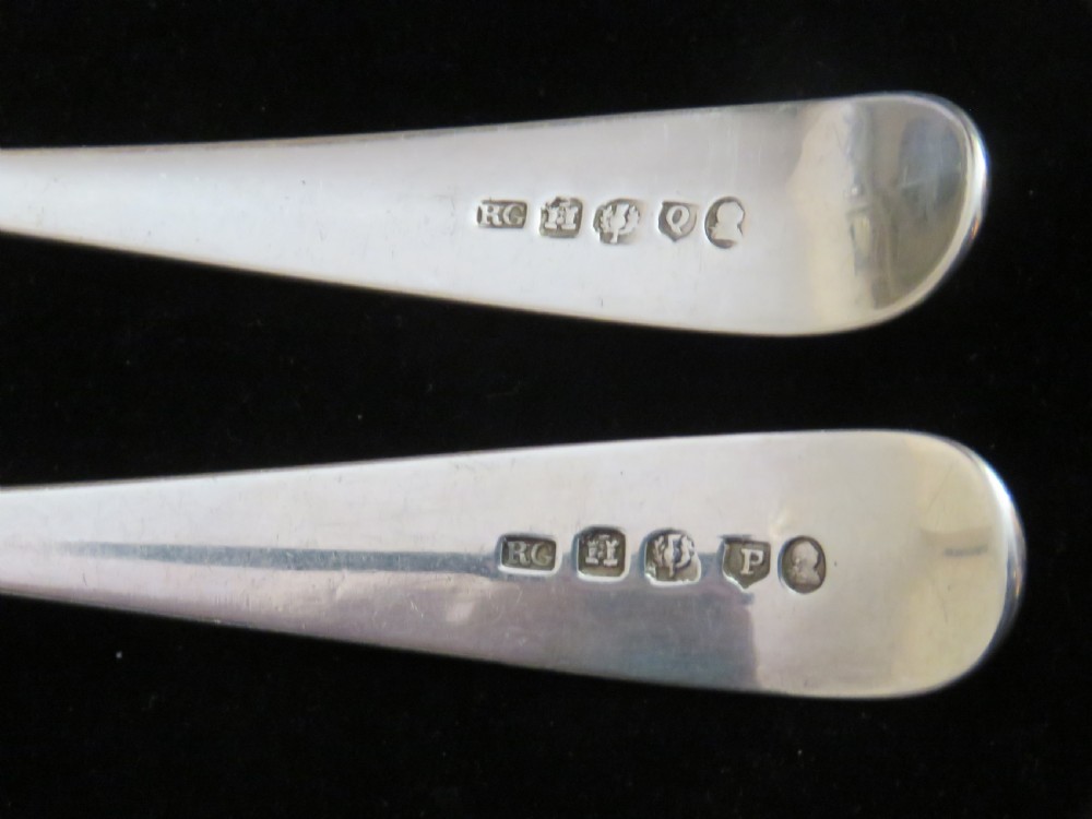 A pair of Georgian sterling silver berry spoons featuring repousse fruit motifs on shaped bowls and detailed engraving along the handles. View IV