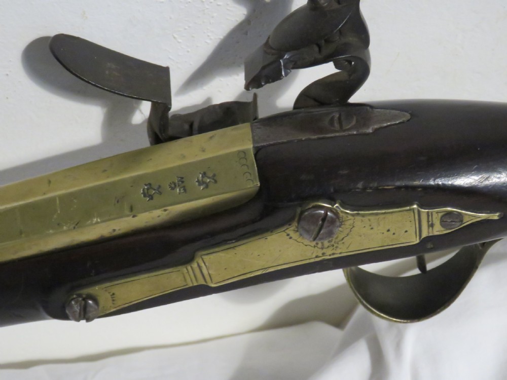 An antique flintlock blunderbuss featuring a flared brass barrel, dark wood stock, iron lock mechanism, and brass trigger guard. View III