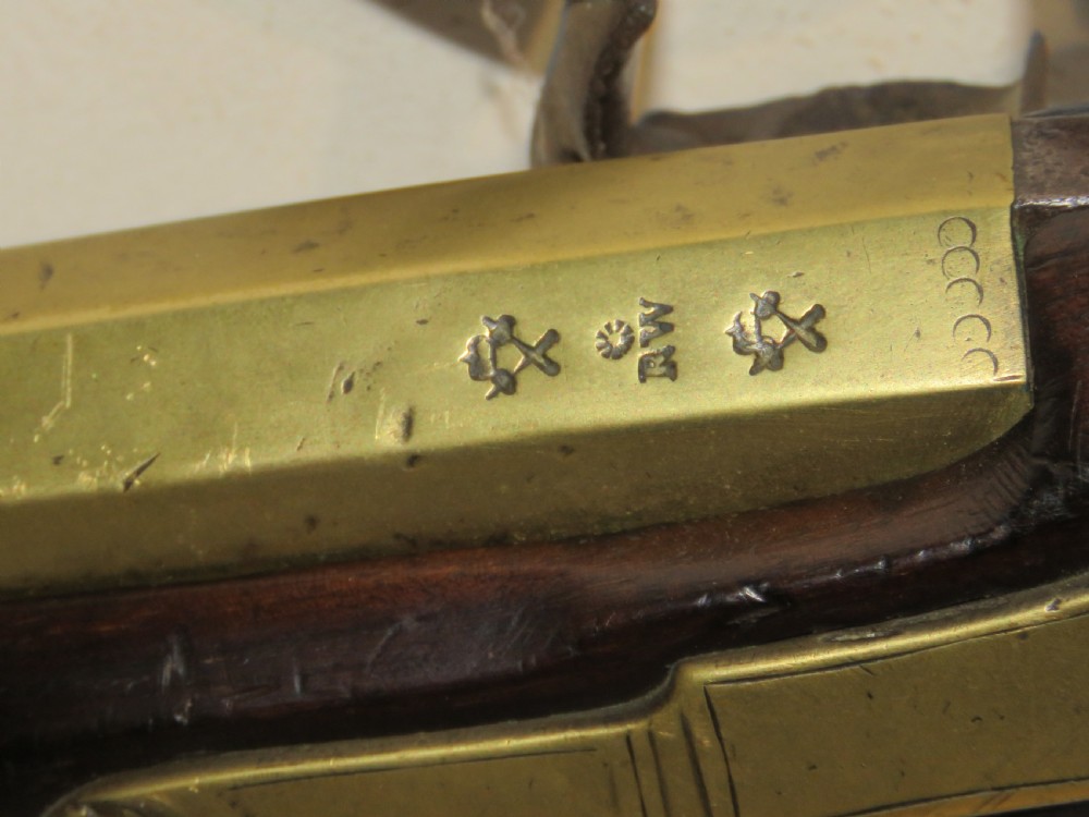 An antique flintlock blunderbuss featuring a flared brass barrel, dark wood stock, iron lock mechanism, and brass trigger guard. View IV