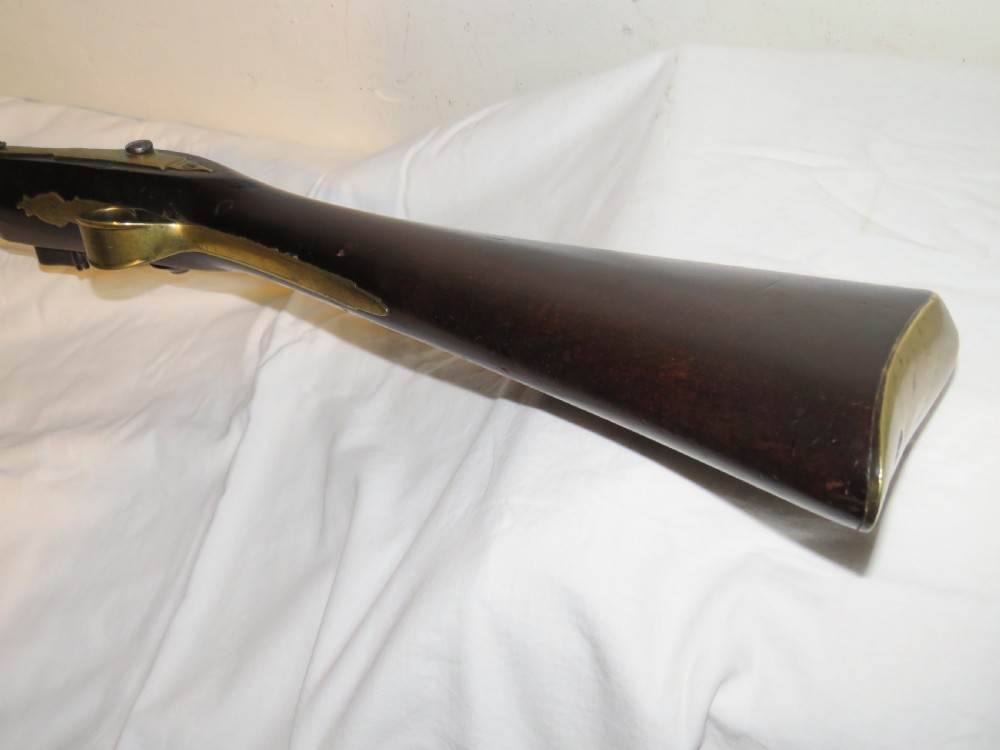 An antique flintlock blunderbuss featuring a flared brass barrel, dark wood stock, iron lock mechanism, and brass trigger guard. View VI