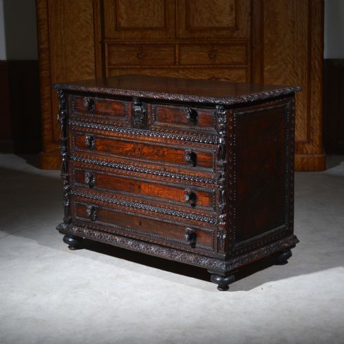 fig 1. A dark carved walnut Italian Renaissance style chest of drawers featuring small carved figural pilasters and turned bun feet.