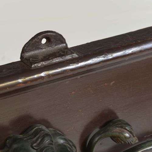 fig 3. A cast bronze lion passant heraldic relief mounted on a rectangular dark red-brown painted wooden plaque.