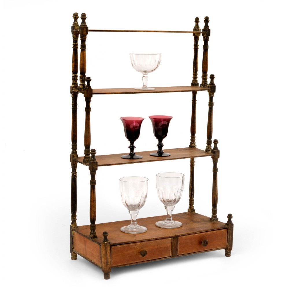 A Regency mahogany tabletop shelving unit with three graduated open tiers supported by turned spindles over a base with two drawers.