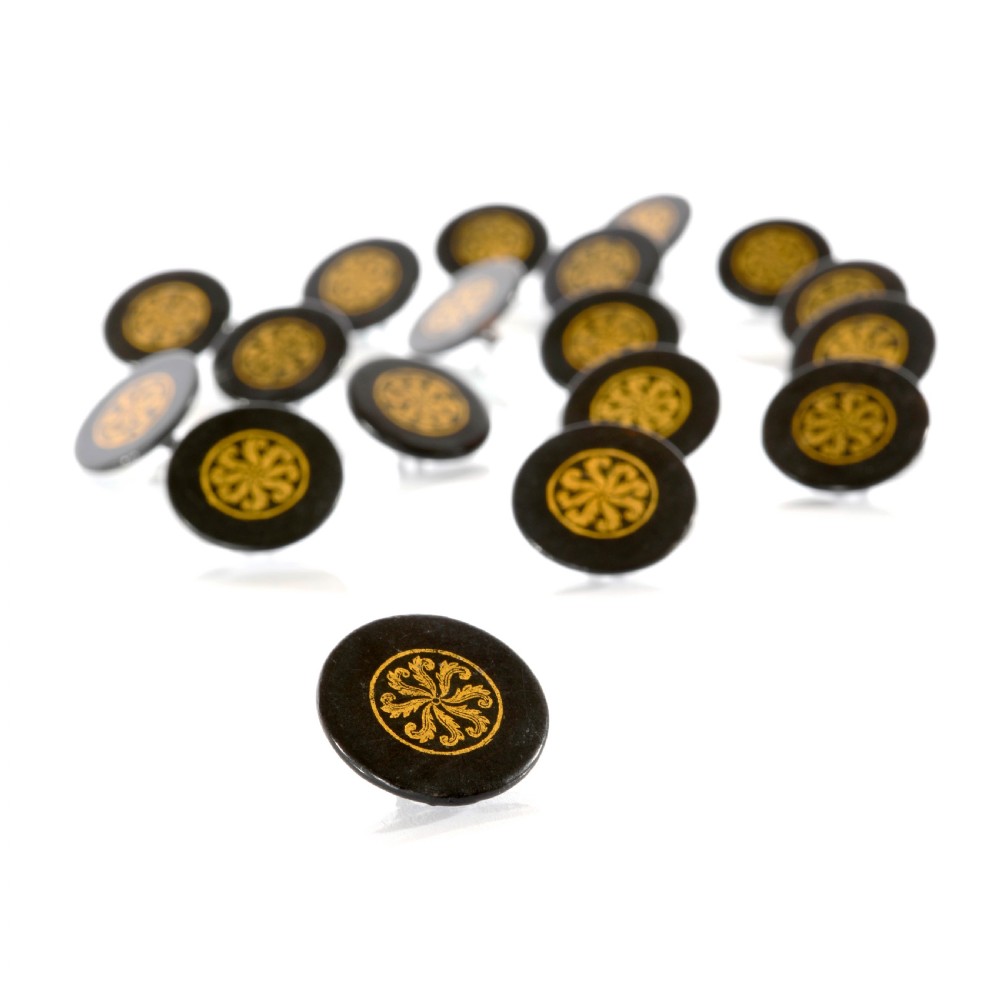 A set of circular black lacquered 19th-century papier-mache buttons with gold painted radial floral motifs.