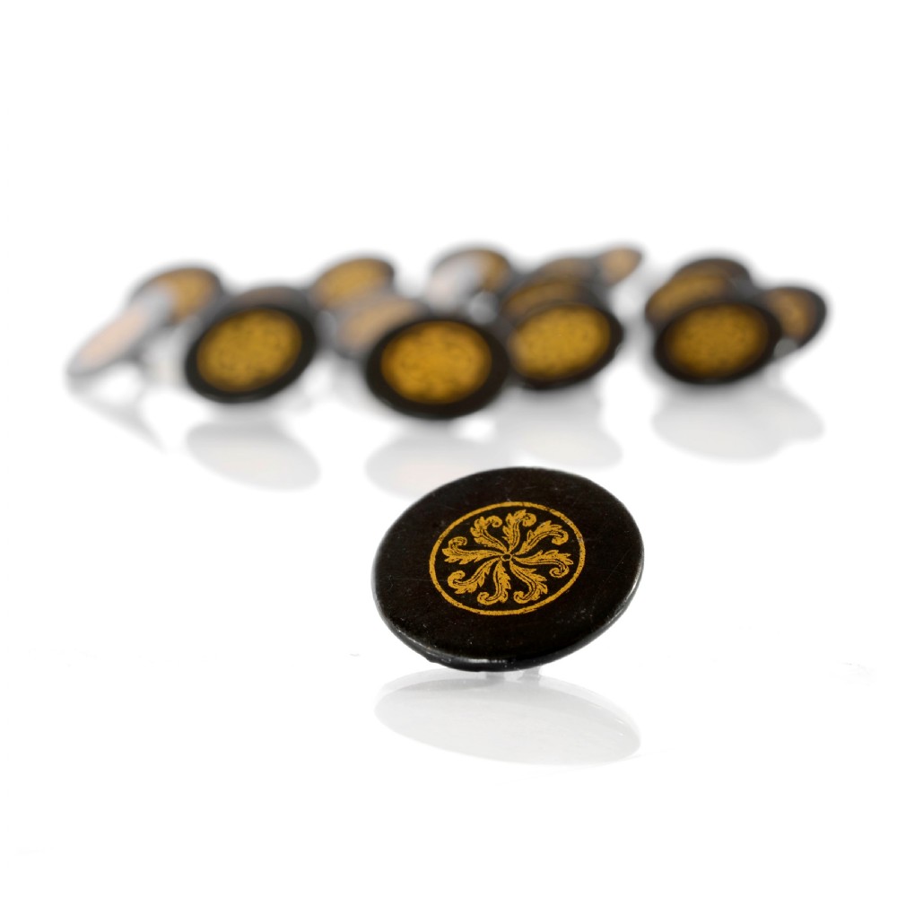 A set of circular black lacquered 19th-century papier-mache buttons with gold painted radial floral motifs. View II