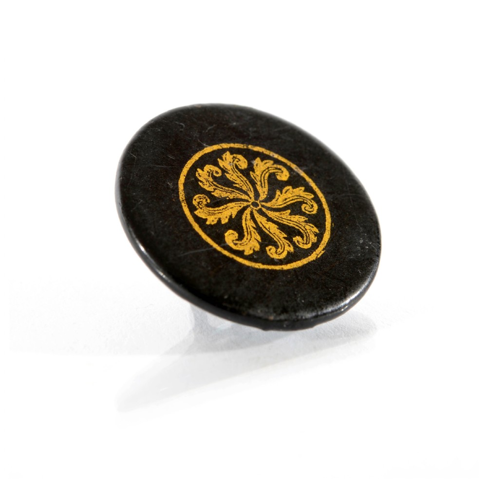 A set of circular black lacquered 19th-century papier-mache buttons with gold painted radial floral motifs. View IV