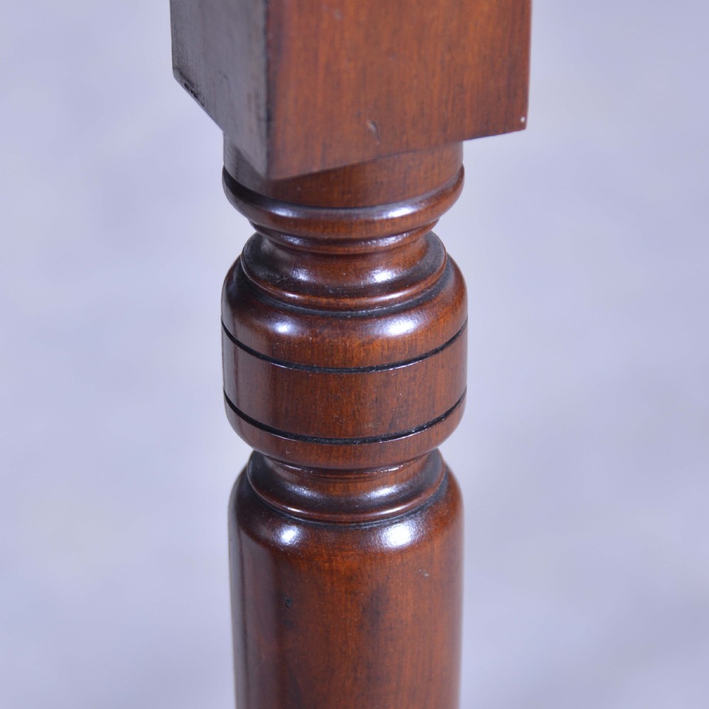 A dark mahogany drop-leaf occasional table featuring a single drawer with two round wooden knobs, four turned legs, and brass castors. View VII