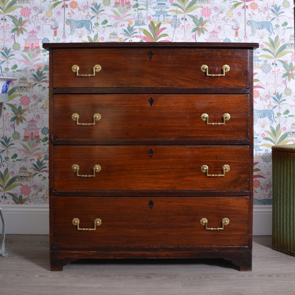 An Anglo-Indian padauk wood chest of drawers featuring four graduated drawers with brass bail handles and bracket feet. View II