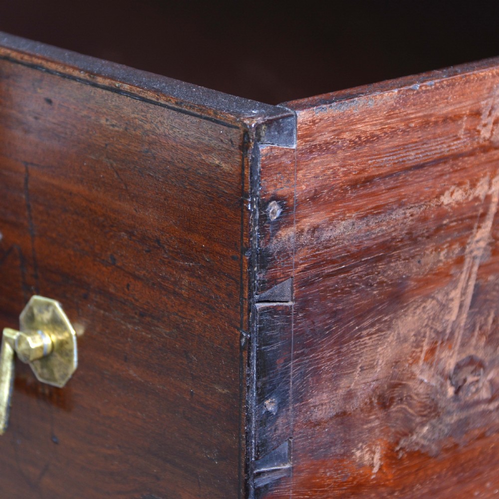 An Anglo-Indian padauk wood chest of drawers featuring four graduated drawers with brass bail handles and bracket feet. View VII