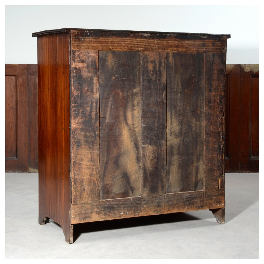 An Anglo-Indian padauk wood chest of drawers featuring four graduated drawers with brass bail handles and bracket feet. View VIII