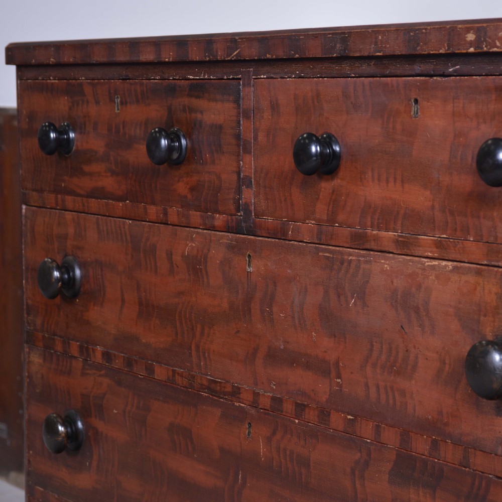 A 19th-century pine chest of drawers featuring a hand-painted scumbled faux-grain finish, two short over three long drawers, dark turned wooden knobs, and a solid plinth base. View III