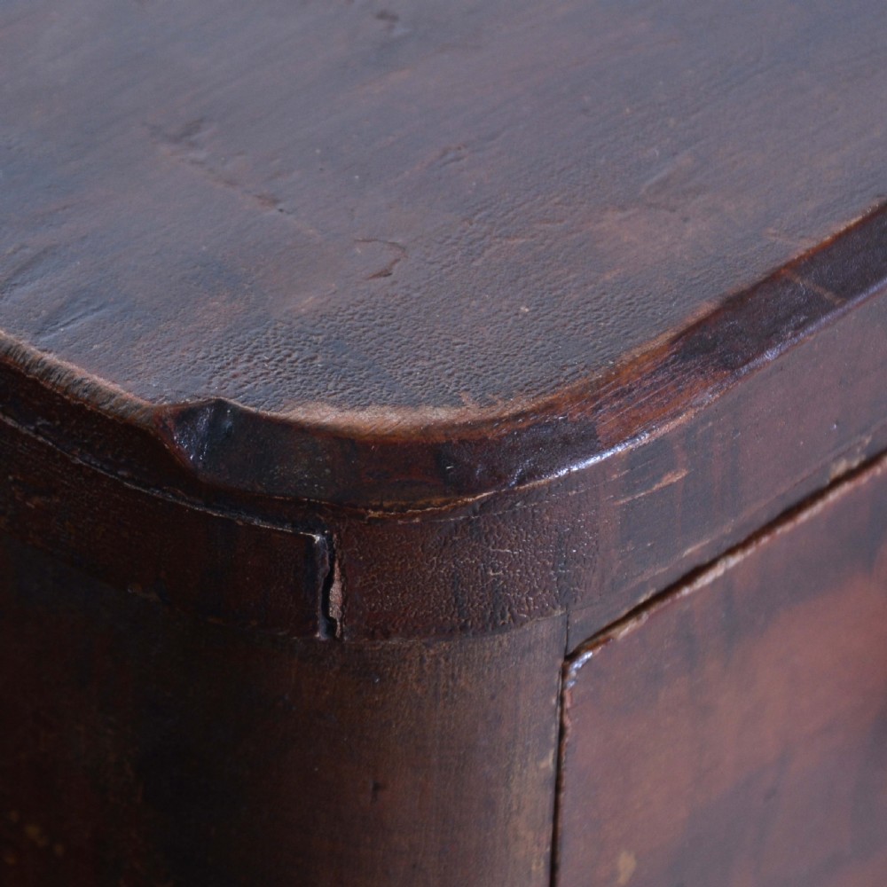 A 19th-century pine chest of drawers featuring a hand-painted scumbled faux-grain finish, two short over three long drawers, dark turned wooden knobs, and a solid plinth base. View V