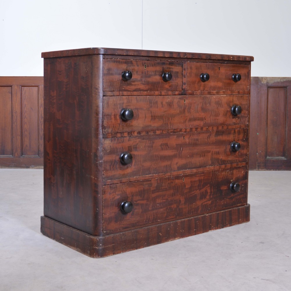 A 19th-century pine chest of drawers featuring a hand-painted scumbled faux-grain finish, two short over three long drawers, dark turned wooden knobs, and a solid plinth base. View VIII