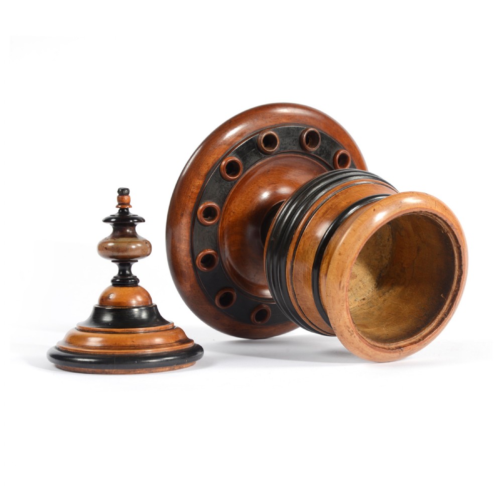 A turned fruitwood tobacco box featuring ebonised ring bands, a tiered lid with a turned finial, and a circular base with pipe holders. View III