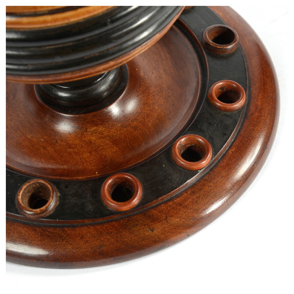 A turned fruitwood tobacco box featuring ebonised ring bands, a tiered lid with a turned finial, and a circular base with pipe holders. View V