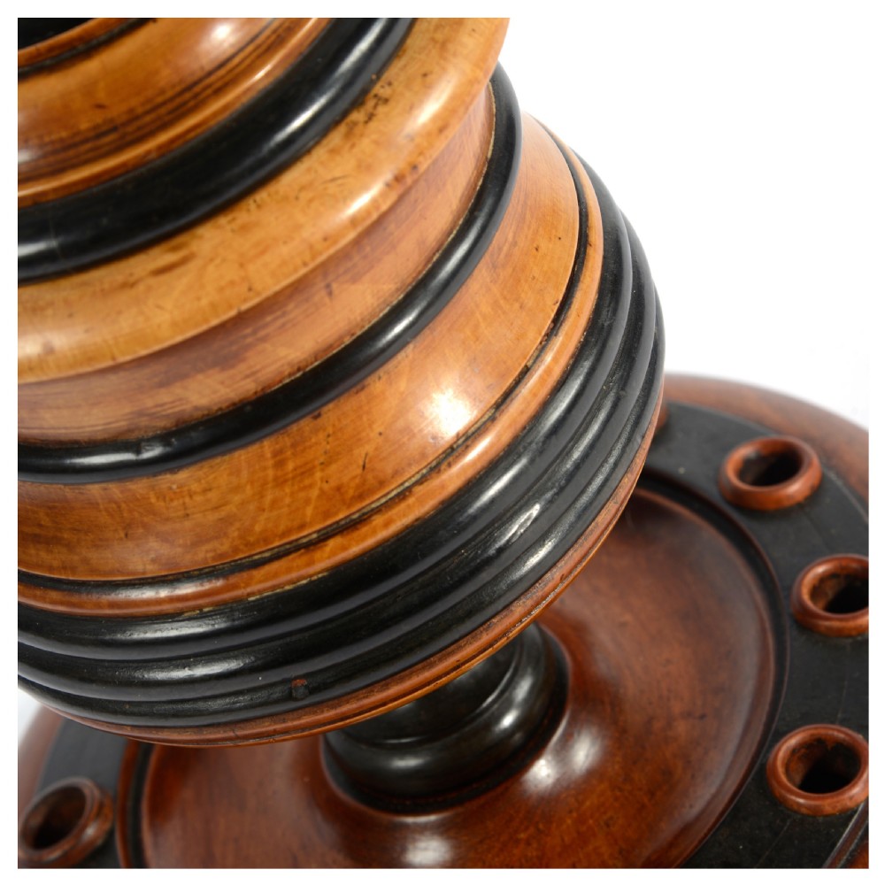 A turned fruitwood tobacco box featuring ebonised ring bands, a tiered lid with a turned finial, and a circular base with pipe holders. View VI
