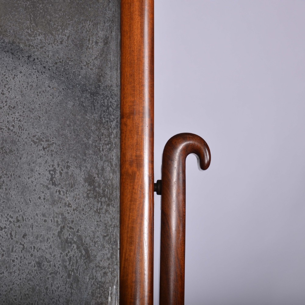 An antique mahogany dressing table mirror featuring a rectangular swivelling frame set between curved upright supports on a solid plinth base. View II