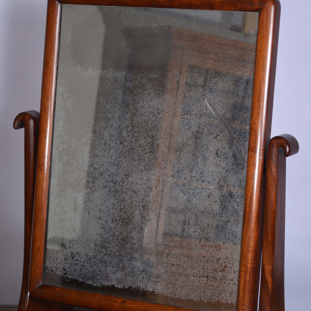 An antique mahogany dressing table mirror featuring a rectangular swivelling frame set between curved upright supports on a solid plinth base. View VII