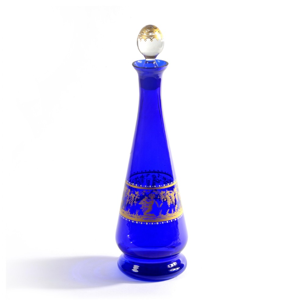 A 19th-century Venetian cobalt blue glass decanter bottle with stopper and matching stemmed glasses featuring gilded classical motifs and clear twisted glass stems. View III