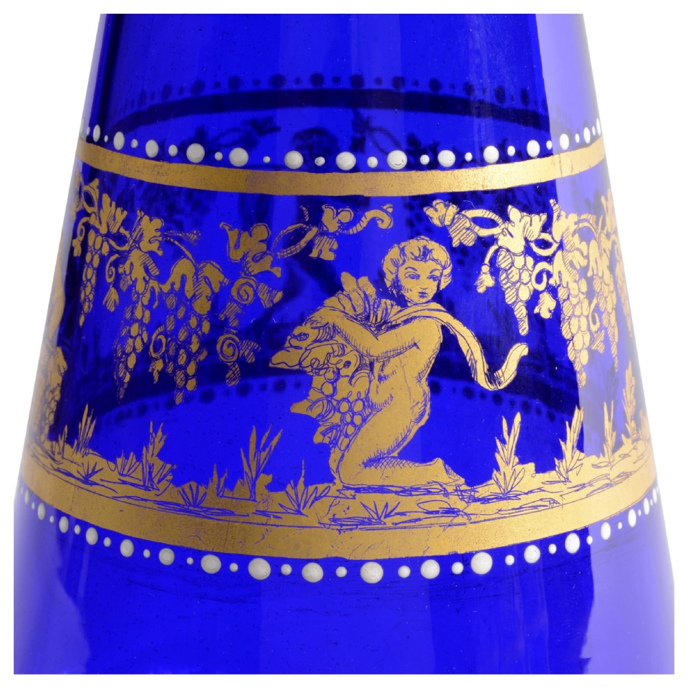 A 19th-century Venetian cobalt blue glass decanter bottle with stopper and matching stemmed glasses featuring gilded classical motifs and clear twisted glass stems. View V