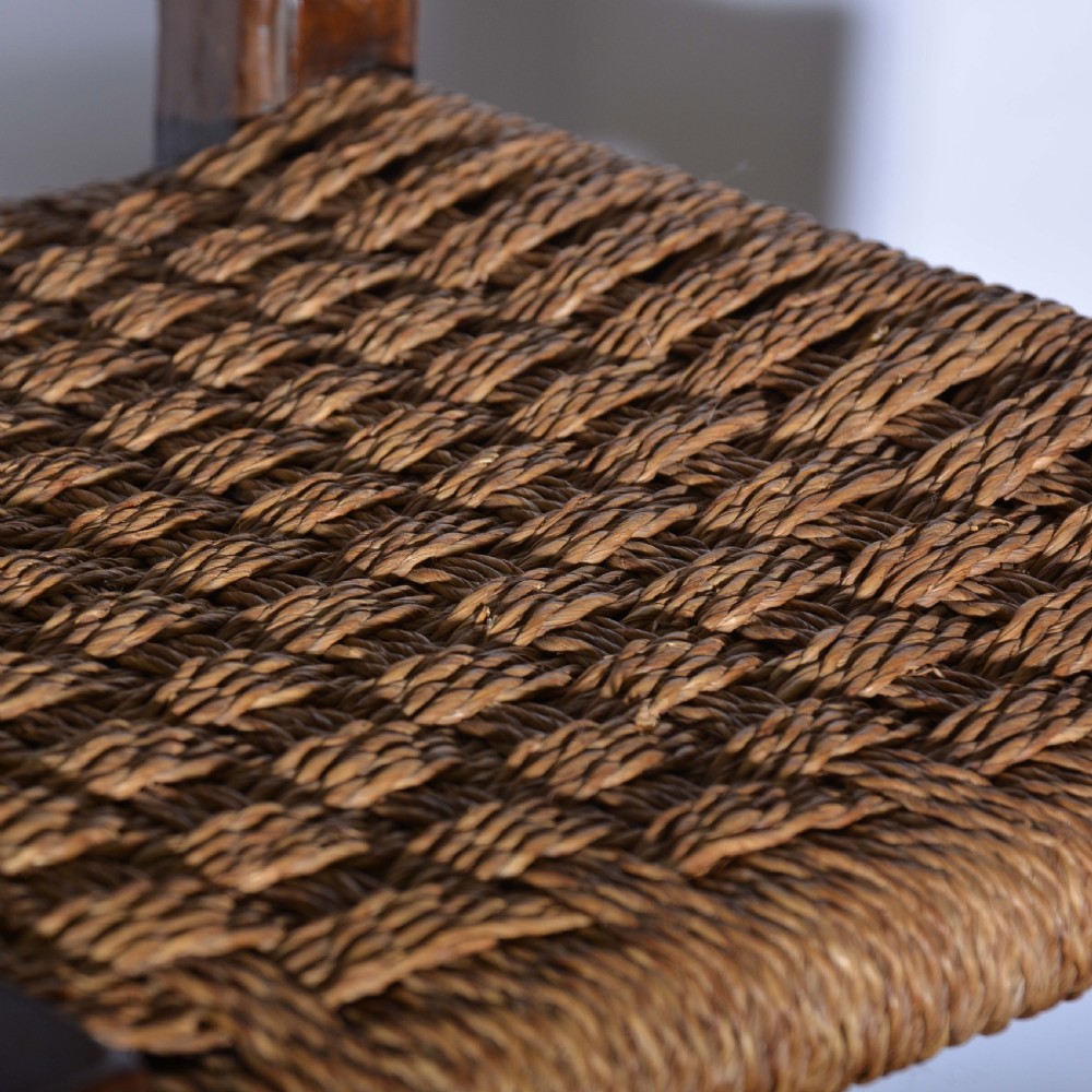 A small Italian country walnut side chair featuring two scroll-carved back splats, a woven rush seat, and sturdy square legs. View V