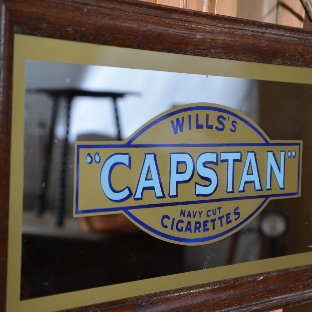 A framed rectangular antique advertising mirror featuring Capstan Navy Cut Cigarettes lettering in blue and gold on a dark background. View III