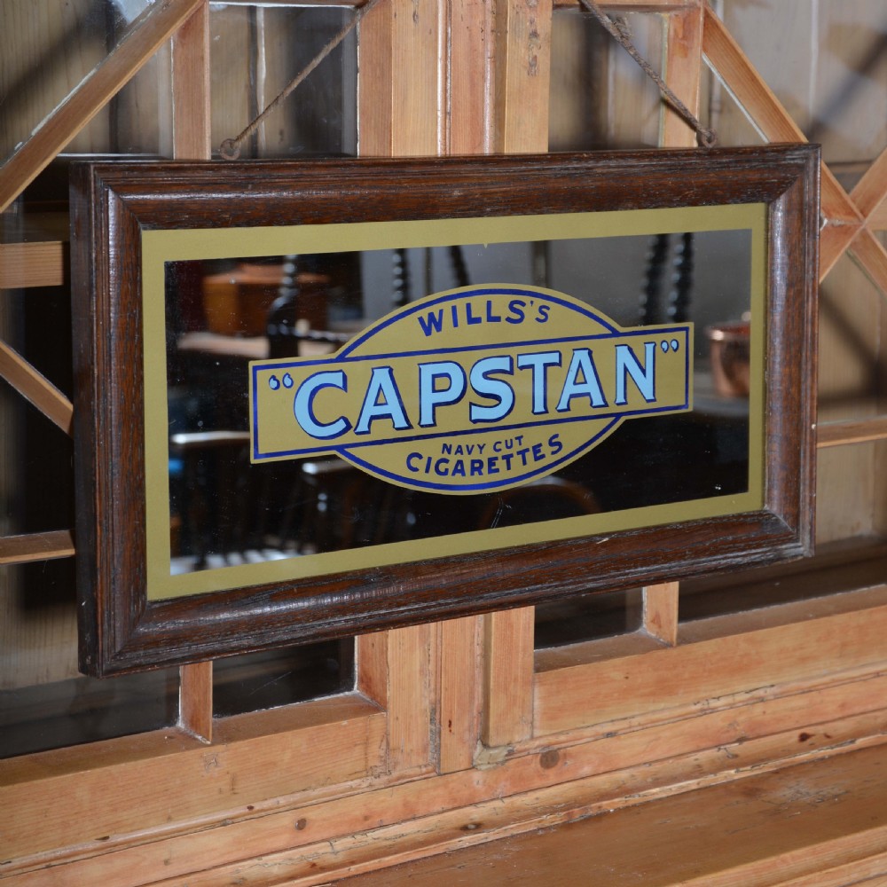 A framed rectangular antique advertising mirror featuring Capstan Navy Cut Cigarettes lettering in blue and gold on a dark background. View IV