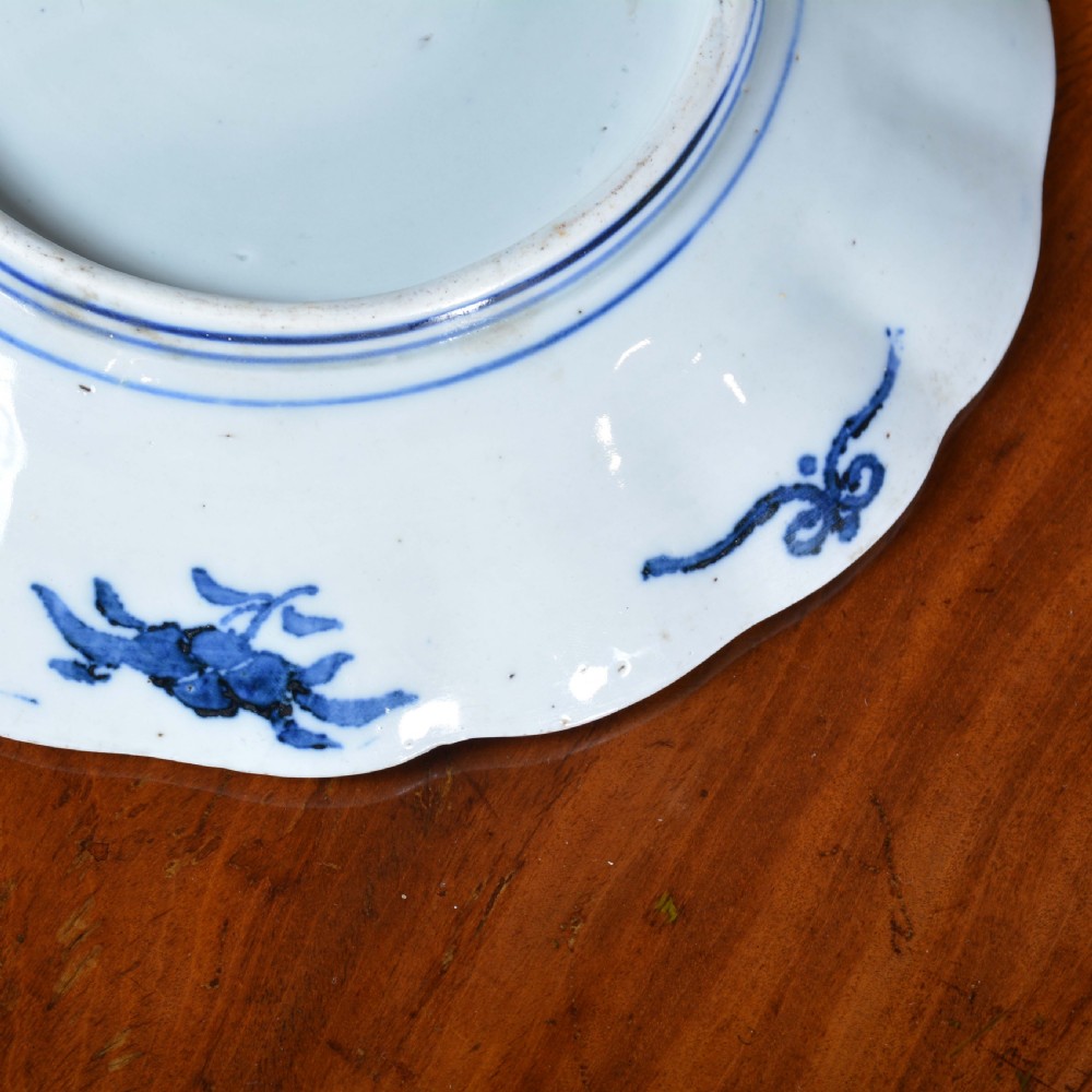 A nineteenth-century Japanese Imari porcelain plate featuring scalloped edges and hand-painted panels of goldfish and floral sprays around a circular central motif in blue and red. View III