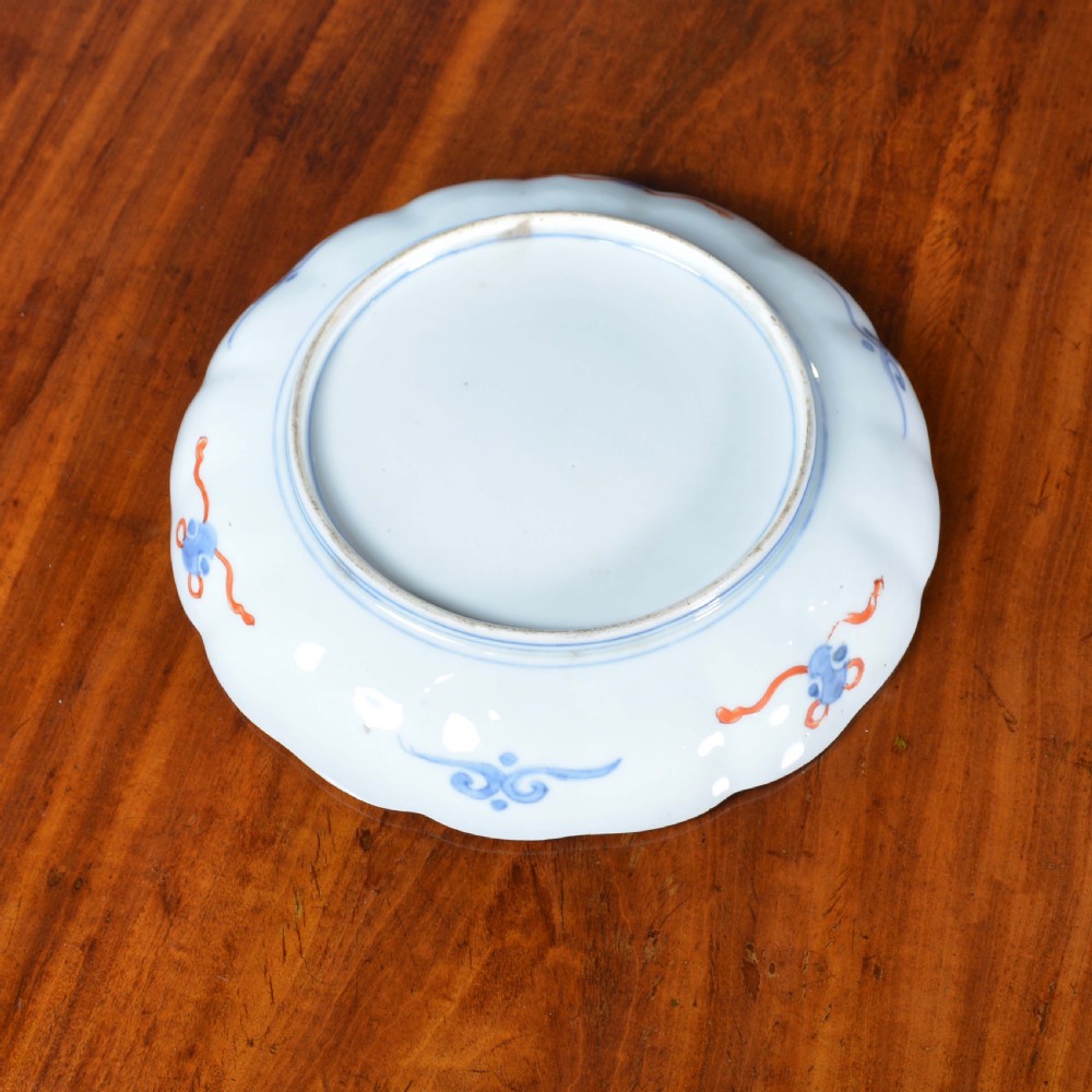 A nineteenth-century Japanese Imari porcelain plate featuring a scalloped rim, hand-painted floral motifs in iron red and green enamels, and cobalt blue brushwork with gold detailing. View III
