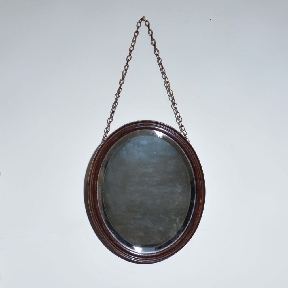 Small red lacquered oval mirror with bevelled edge