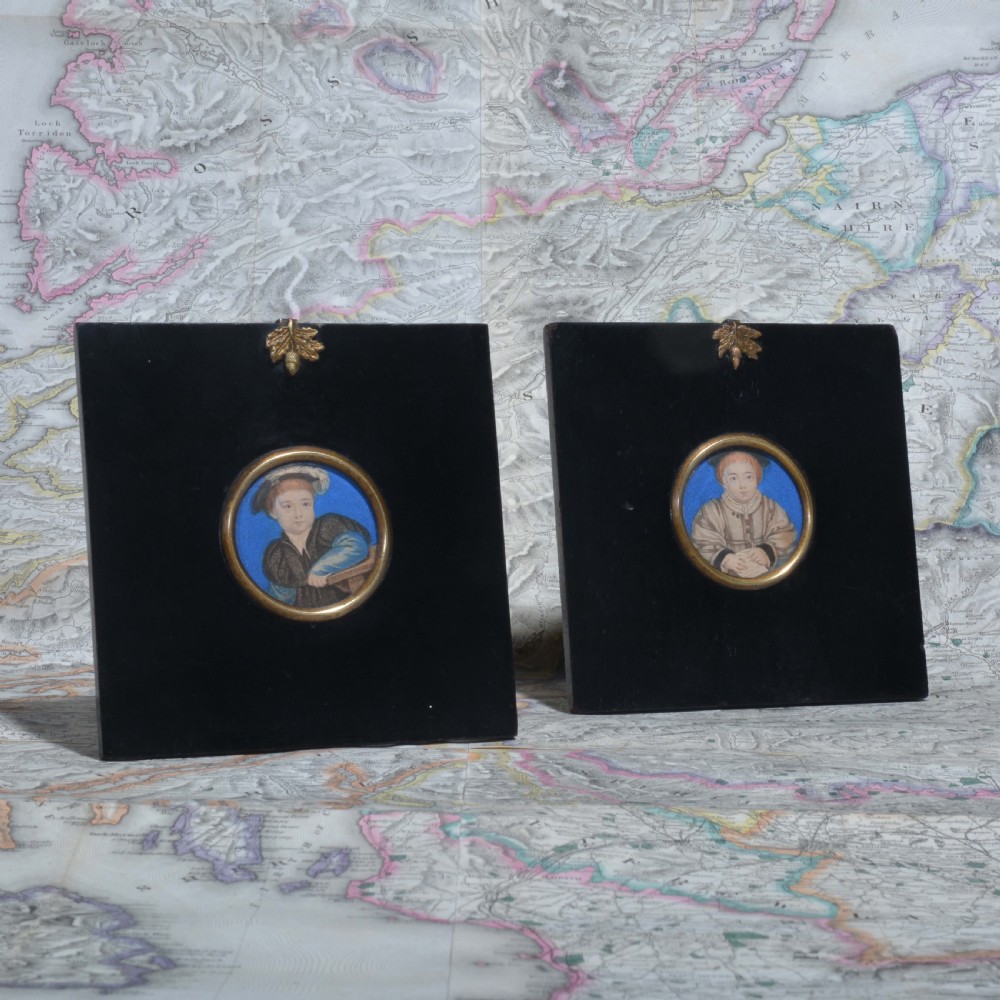 A pair of square ebonised framed portrait miniatures featuring Tudor figures in oval gilt bezels topped with brass acorn hangers. View II