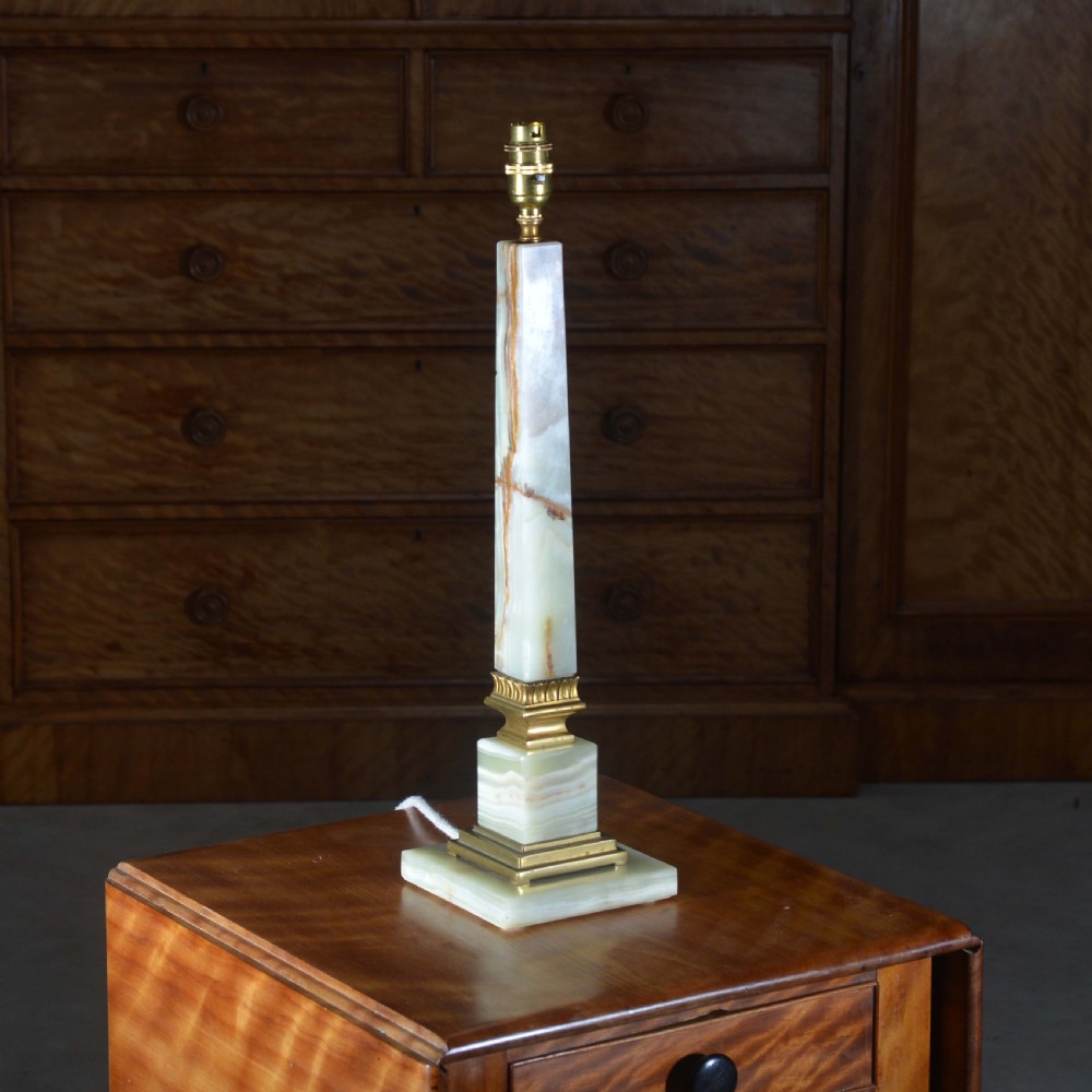 A tapered pale green onyx column table lamp featuring gilt brass collar details and a black fabric lamp shade. View II
