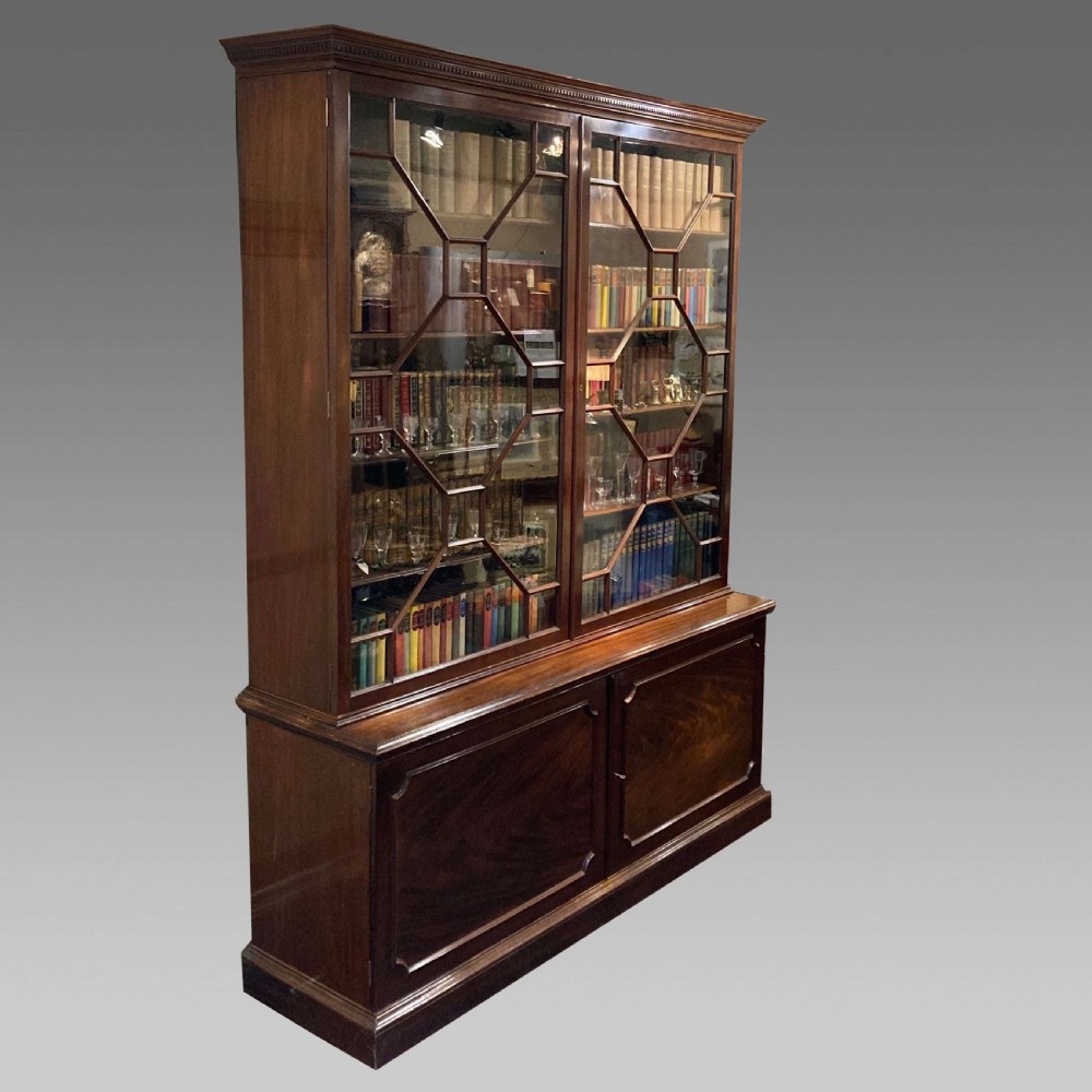 A tall Georgian mahogany bookcase with two astragal glazed upper doors and a panelled twin-door base.
