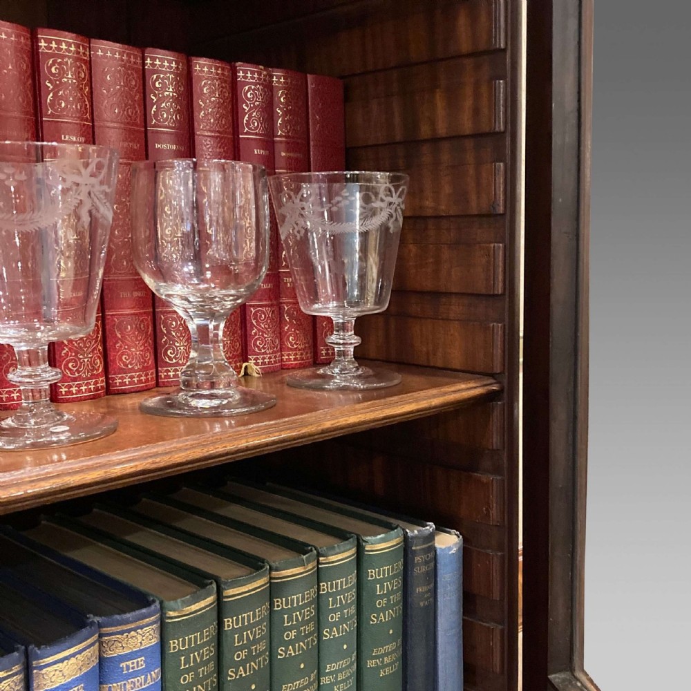A tall Georgian mahogany bookcase with two astragal glazed upper doors and a panelled twin-door base. View V