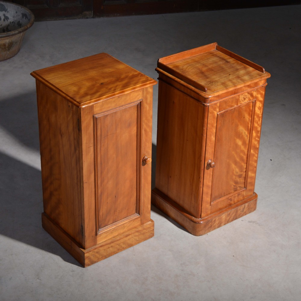 A near pair of Victorian satin birch bedside cabinets featuring single panelled doors, turned timber knobs, and plinth bases. View III